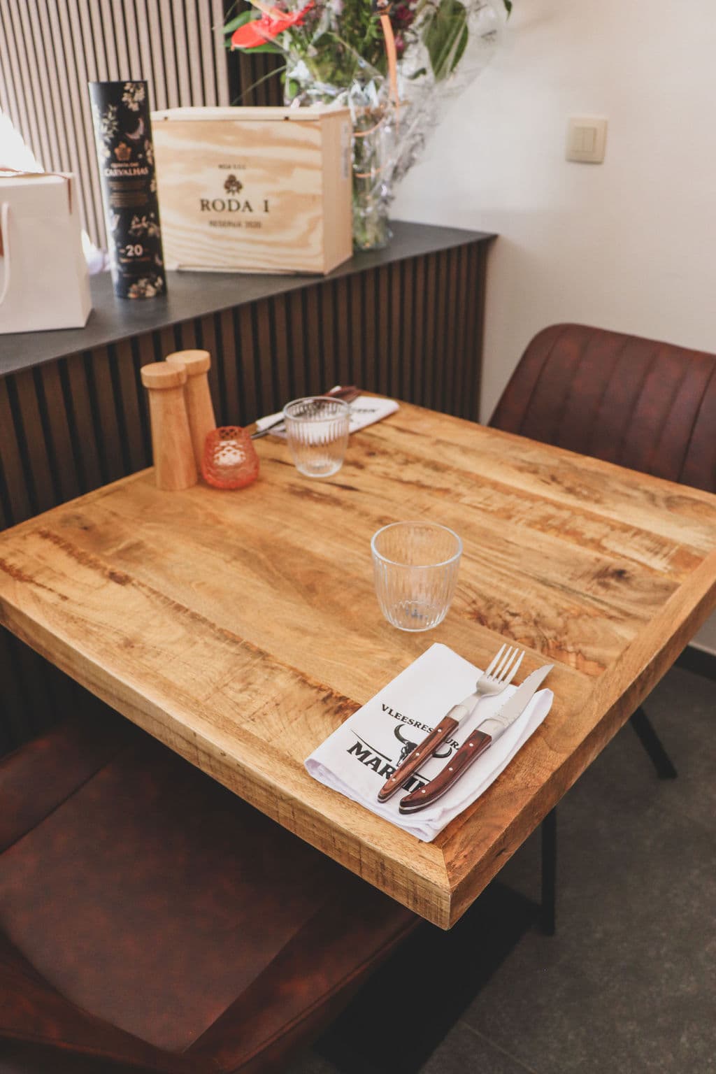 Gedekte tafel bij Vleesrestaurant Martin met servet, bestek en cognackleurige leren stoelen