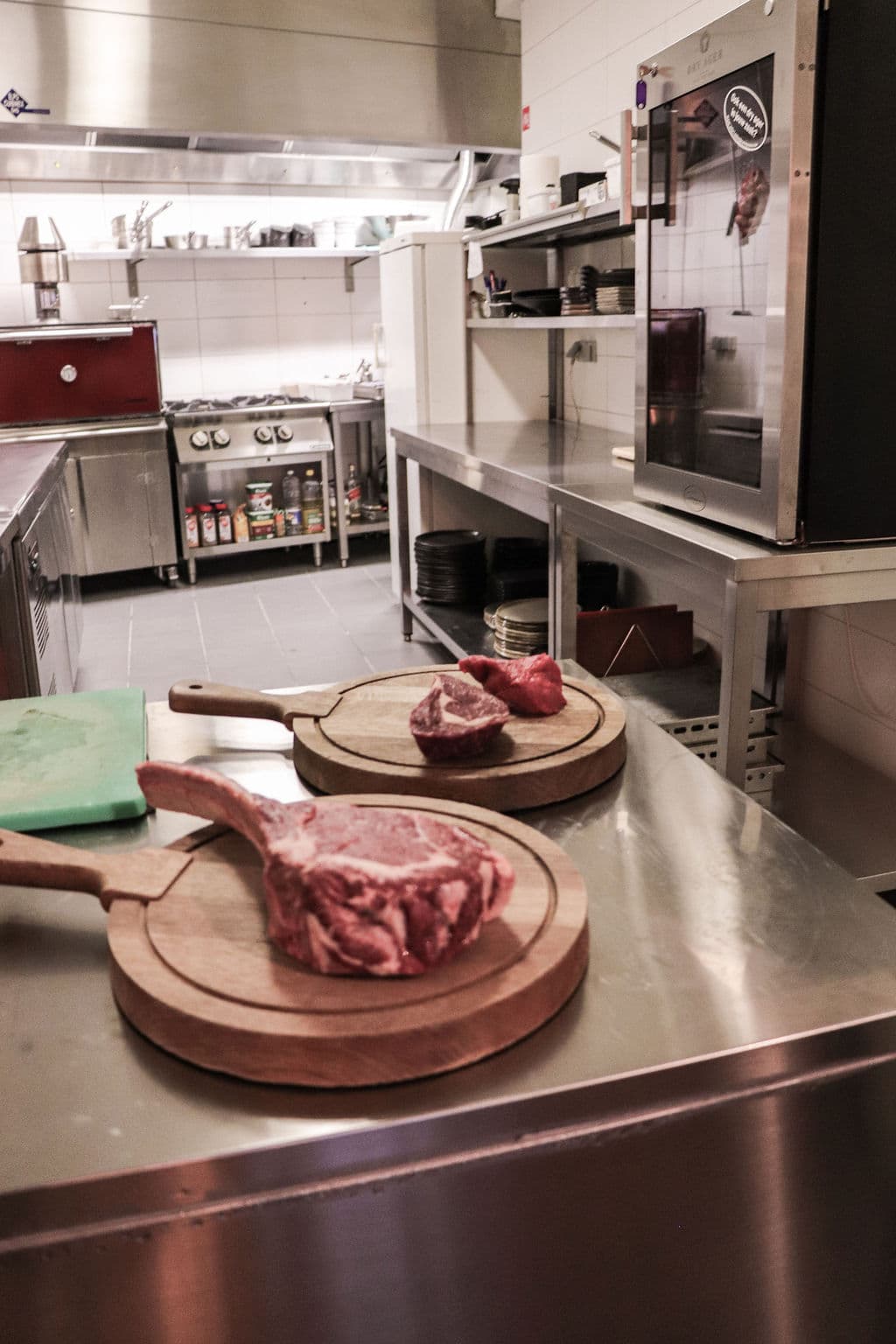 Rauwe tomahawks op houten serveerplanken in de keuken, klaar voor de Josper